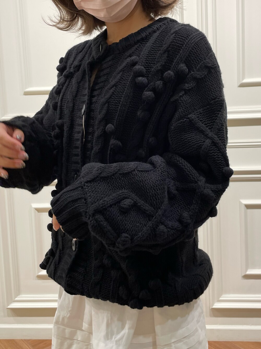 ブラック系のニット/セーター、ホワイト系のスカートを着用したレディースの冬コーディネートの3枚目の写真