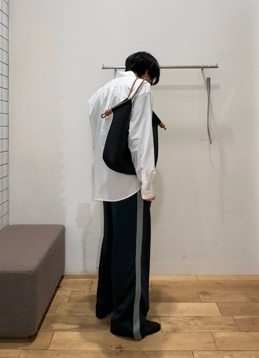 ブラック系のその他シューズ、グリーン系のその他パンツ、ブラック系のトートバッグを着用したメンズの冬コーディネートの2枚目の写真