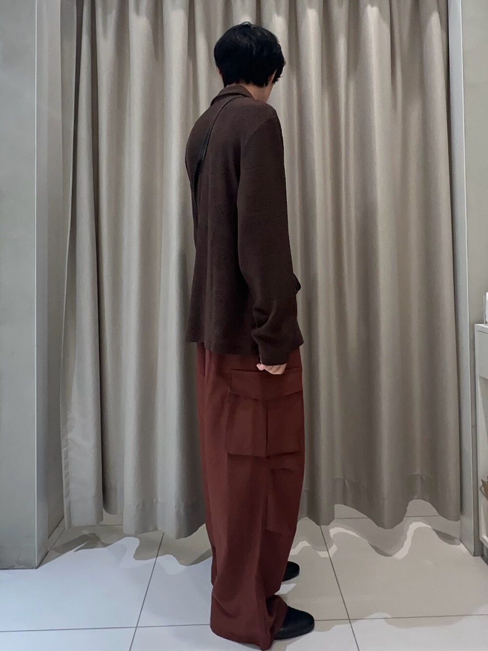 ブラウン系のポロシャツ、ブラウン系のカーゴパンツ、ブラック系のショルダーバッグを着用したメンズの夏コーディネートの2枚目の写真