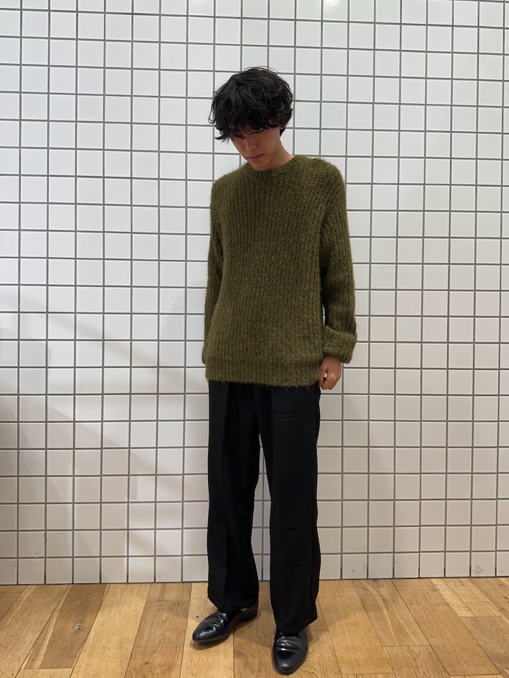 グレー系のモッズコート、グリーン系のニット/セーター、ブラック系のその他パンツを着用したメンズの秋コーディネートの2枚目の写真