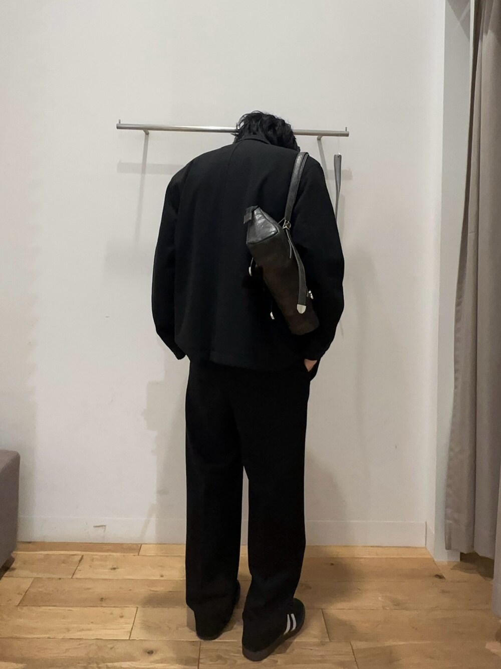 レッド系のニット/セーター、ブラック系のその他アウター、ブラック系のスラックスを着用したメンズの冬コーディネートの2枚目の写真