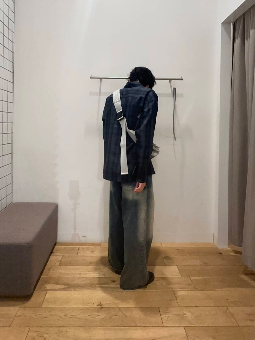 グレー系のショルダーバッグ、ブラック系のTシャツ/カットソー、ブルー系のデニムパンツを着用したメンズの冬コーディネートの2枚目の写真