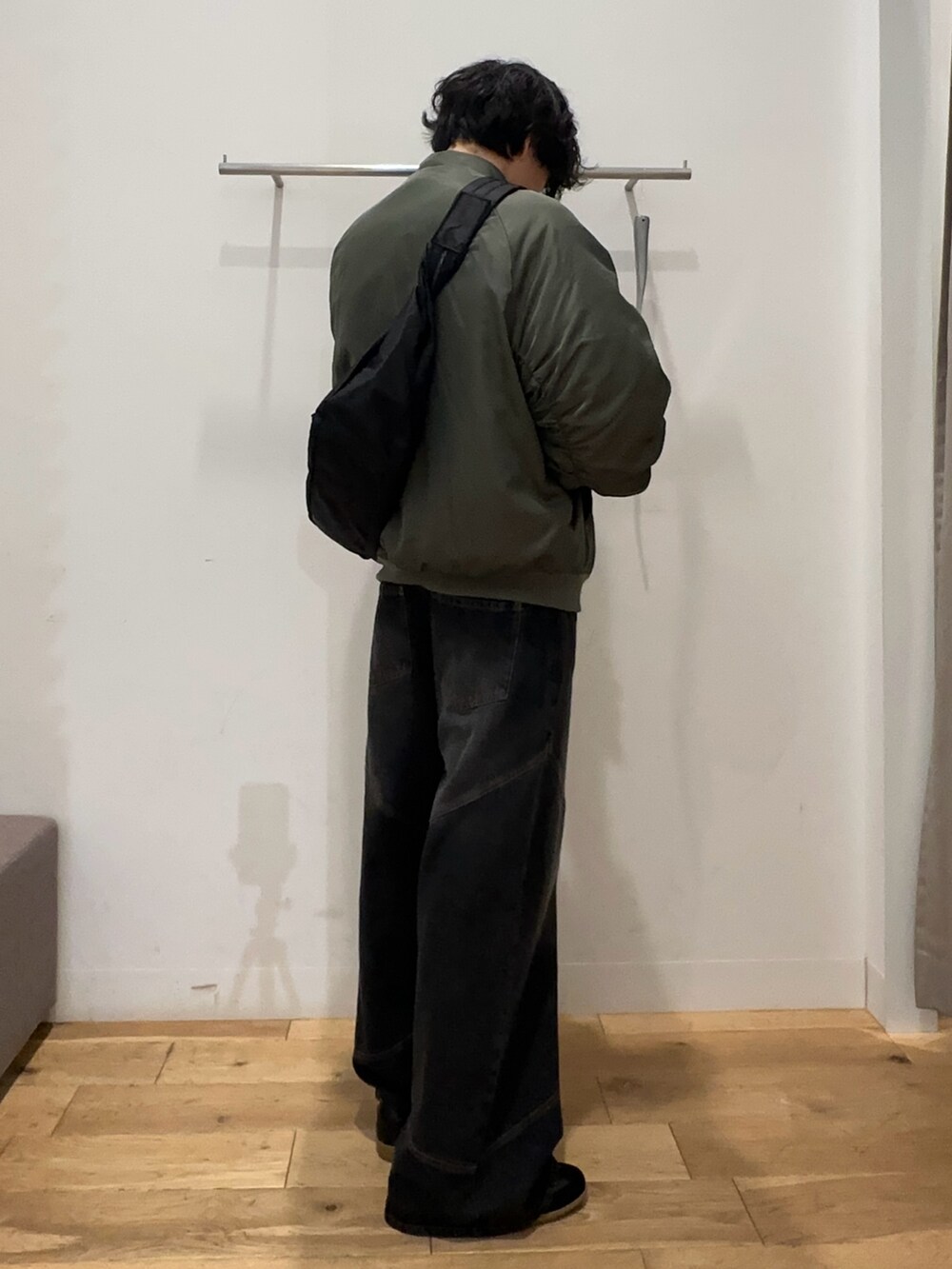 グリーン系のナイロンジャケット、ブラウン系のスウェット、ブラック系のその他パンツを着用したメンズの秋コーディネートの2枚目の写真