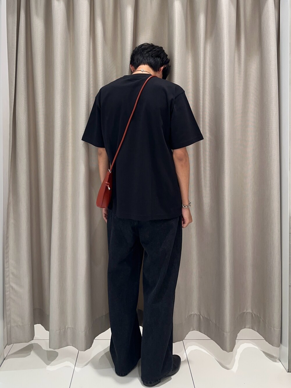 オレンジ系のショルダーバッグ、ブラック系のデニムパンツ、ブラック系のTシャツ/カットソーを着用したメンズの夏コーディネートの2枚目の写真