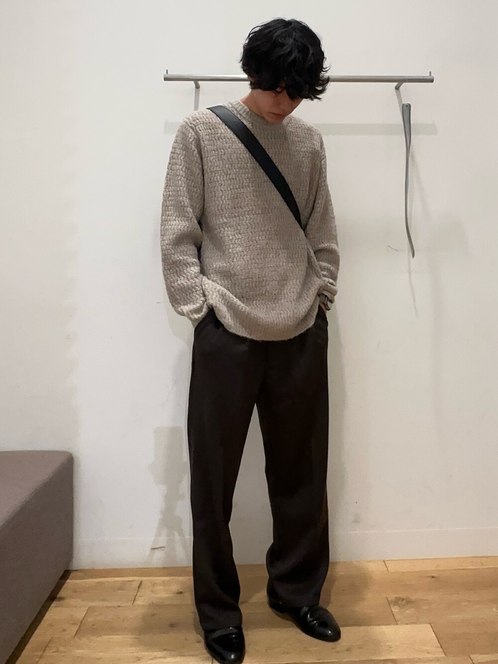 ブラック系のステンカラーコート、ホワイト系のニット/セーター、グレー系のその他パンツを着用したメンズの秋コーディネートの2枚目の写真