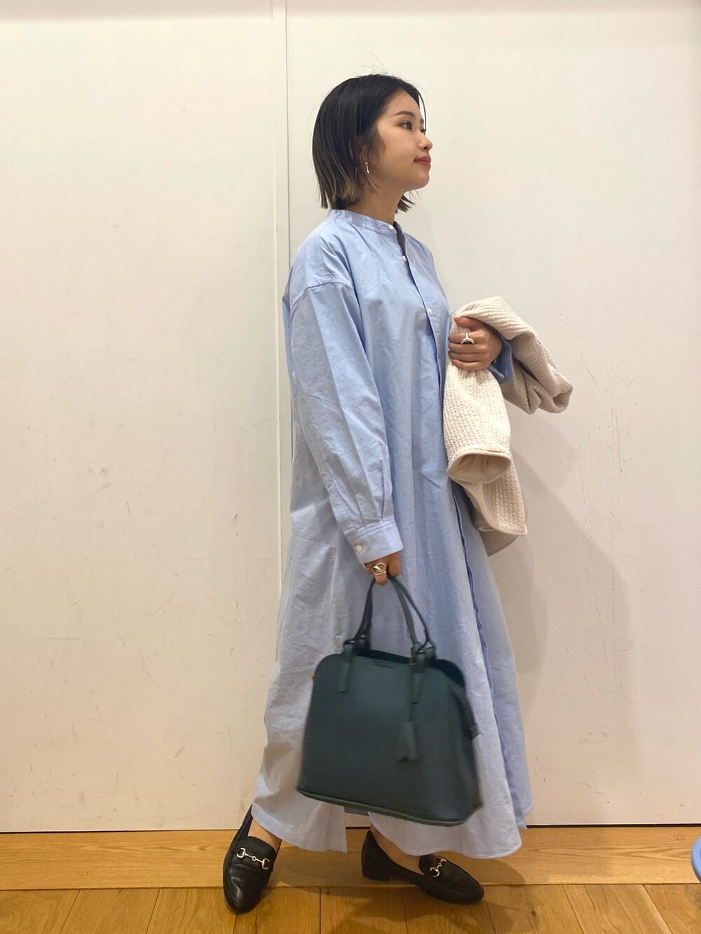 ブラック系のローファー、グリーン系のハンドバッグを着用したレディースの秋コーディネートの3枚目の写真