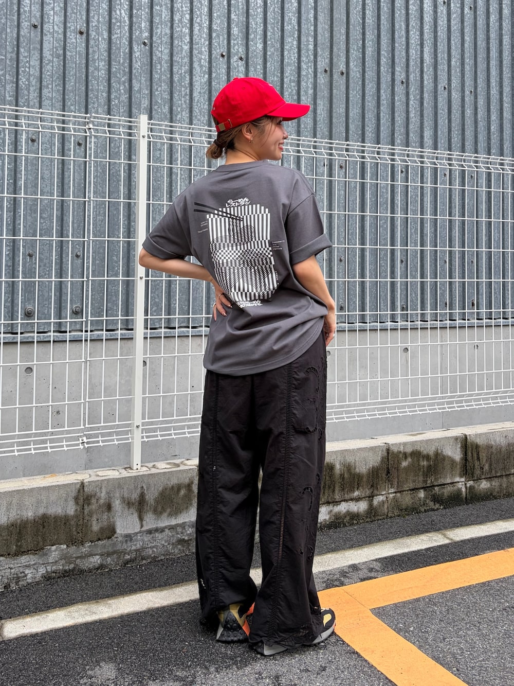 ブラック系のその他パンツ、グレー系のTシャツ/カットソー、レッド系のキャップを着用したレディースの夏コーディネートの3枚目の写真