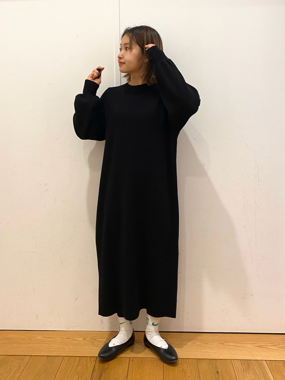 イエロー系のダウンジャケット/コート、ブラック系のワンピース、ブラック系のパンプスを着用したレディースの冬コーディネートの2枚目の写真