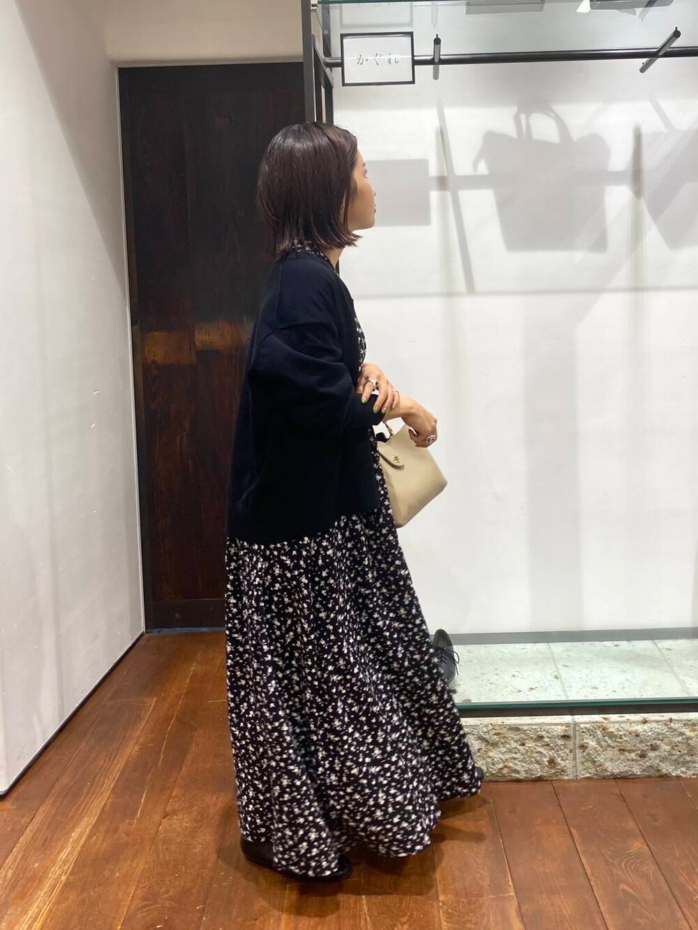 ブラック系のワンピース、ベージュ系のショルダーバッグ、ブラック系のカーディガン/ボレロを着用したレディースの夏コーディネートの3枚目の写真