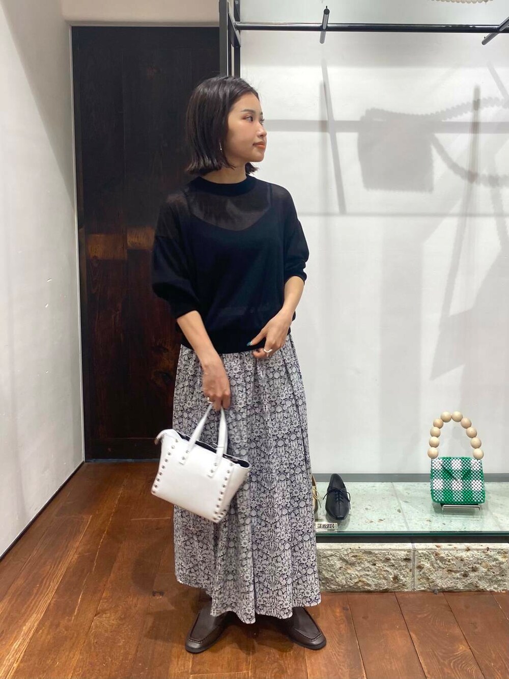 ブラウン系のサンダル、ブルー系のニット/セーター、ホワイト系のショルダーバッグを着用したレディースの夏コーディネートの2枚目の写真