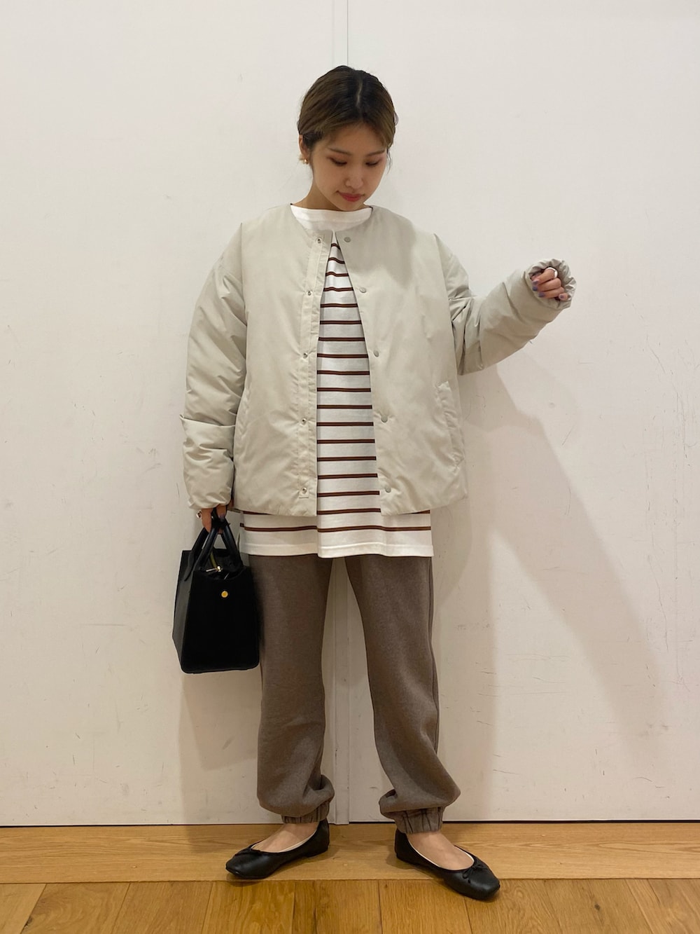 ブラウン系のスウェットパンツ、ブラウン系のTシャツ/カットソー、ブラック系のショルダーバッグを着用したレディースの秋コーディネートの3枚目の写真