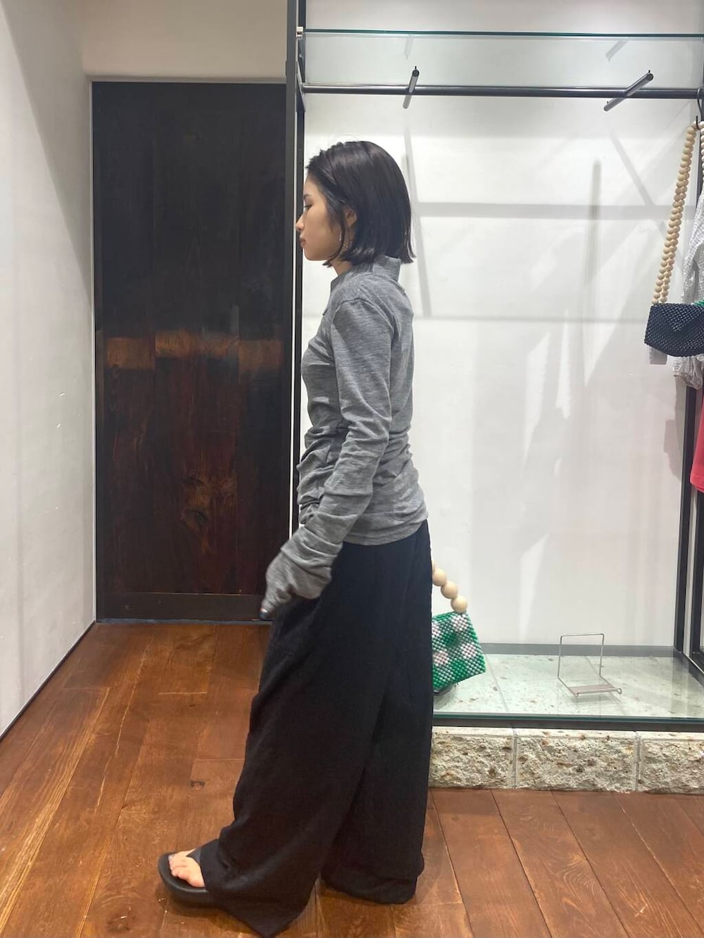 ブラック系のその他パンツ、その他のハンドバッグ、グレー系のニット/セーターを着用したレディースの夏コーディネートの4枚目の写真