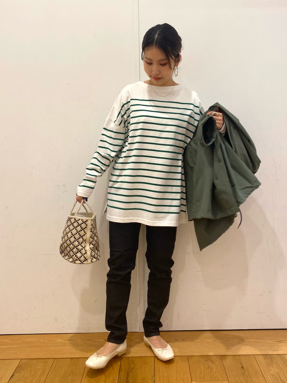 ブラック系のデニムパンツ、グリーン系のモッズコート、グリーン系のTシャツ/カットソーを着用したレディースの春コーディネートの2枚目の写真