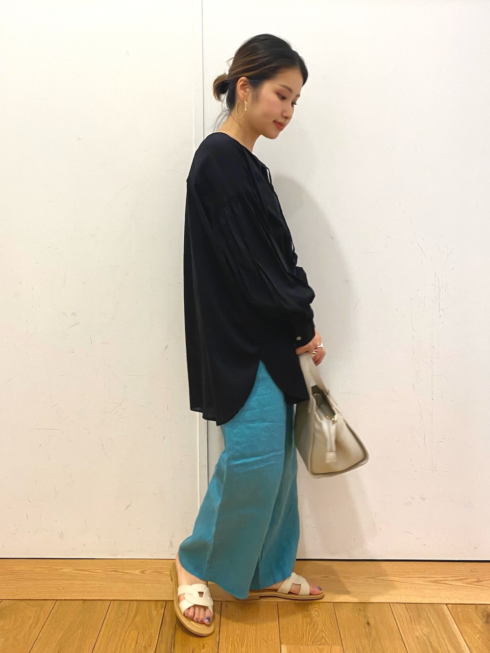 ホワイト系のハンドバッグ、ブラック系のシャツ/ブラウス、ブルー系のその他パンツを着用したレディースの春コーディネートの2枚目の写真