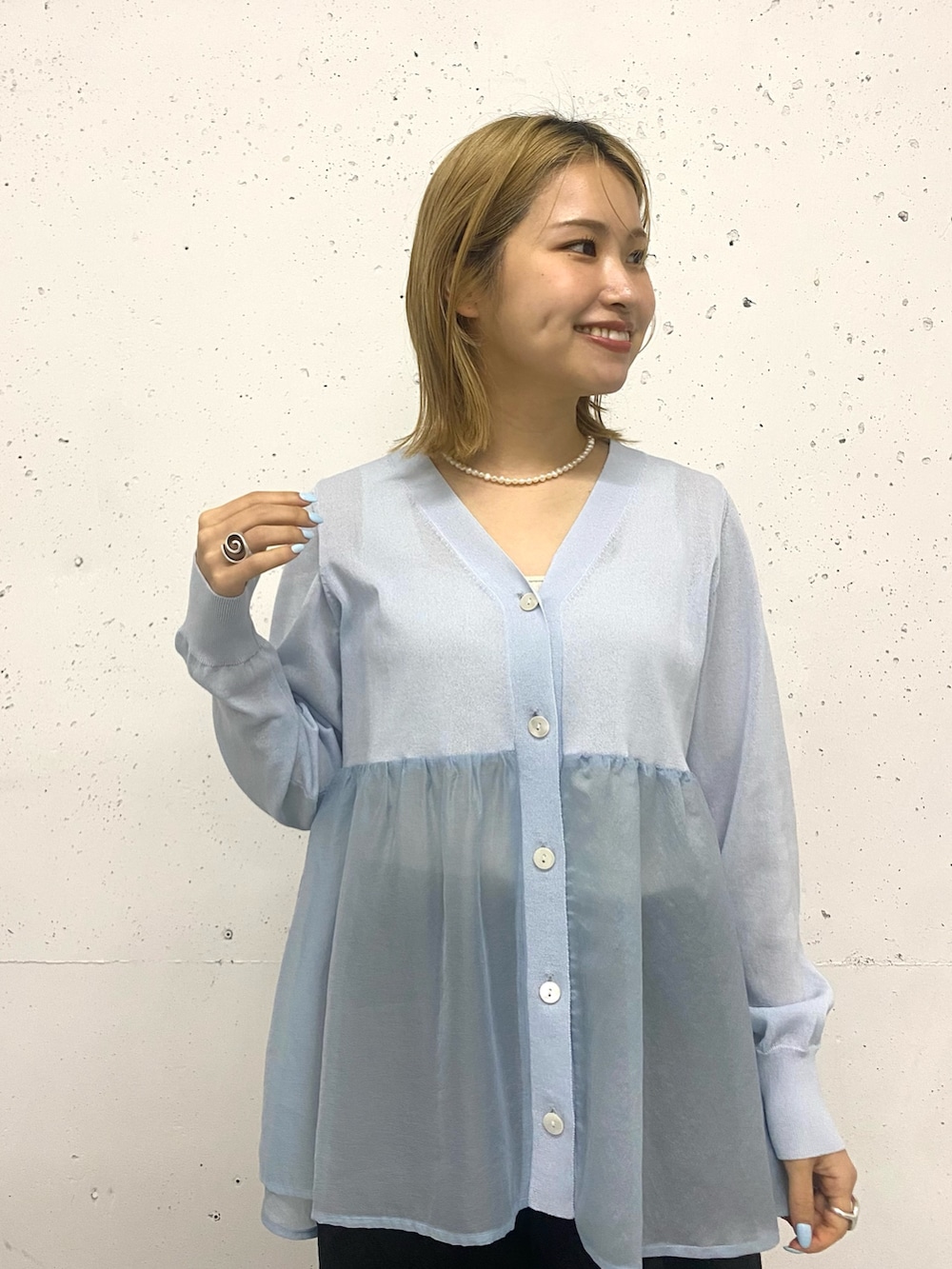 ブルー系のニット/セーターを着用したレディースの春コーディネートの3枚目の写真