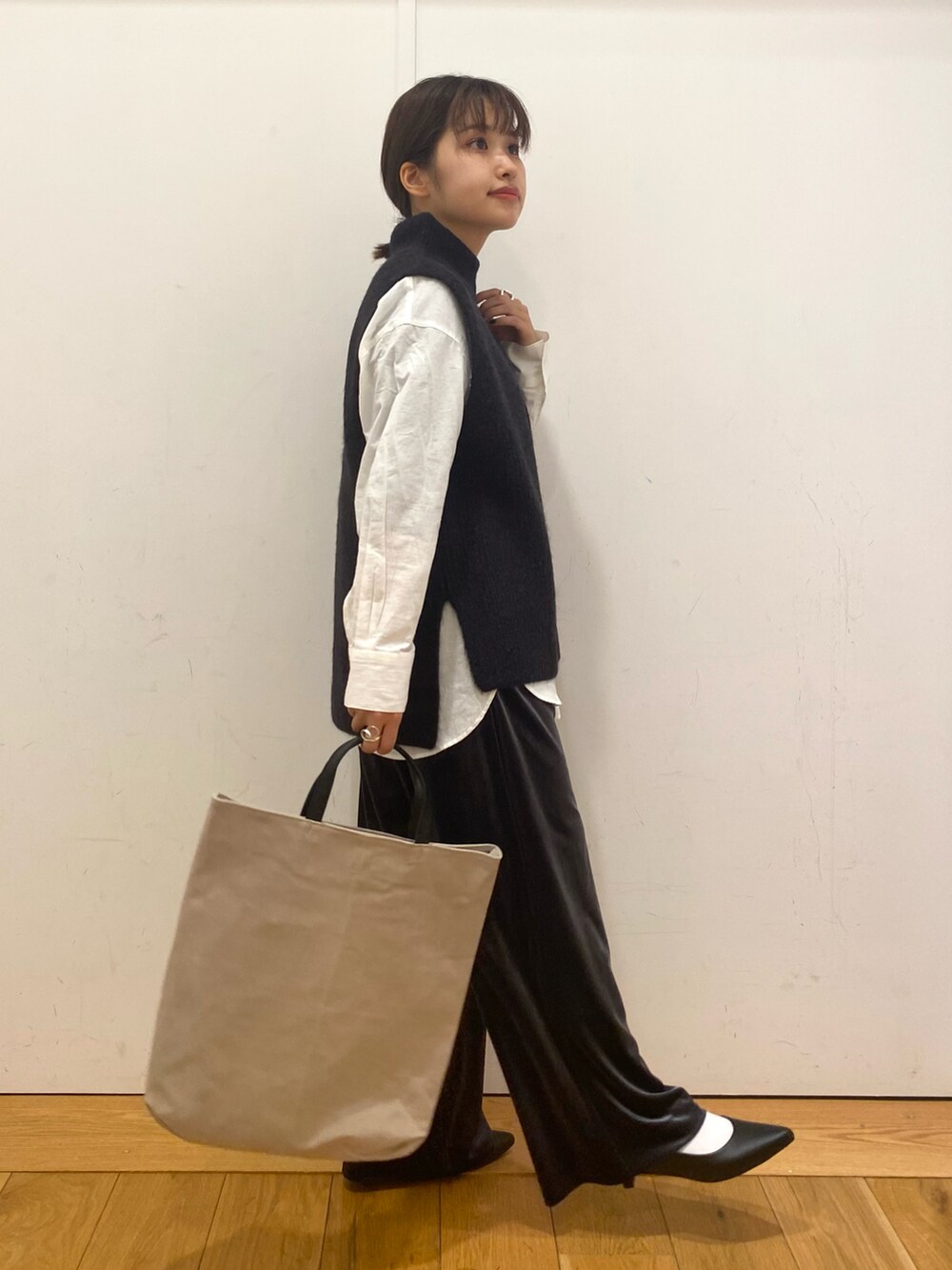 グレー系のその他パンツ、ブルー系のベスト、ホワイト系のシャツ/ブラウスを着用したレディースの冬コーディネートの2枚目の写真