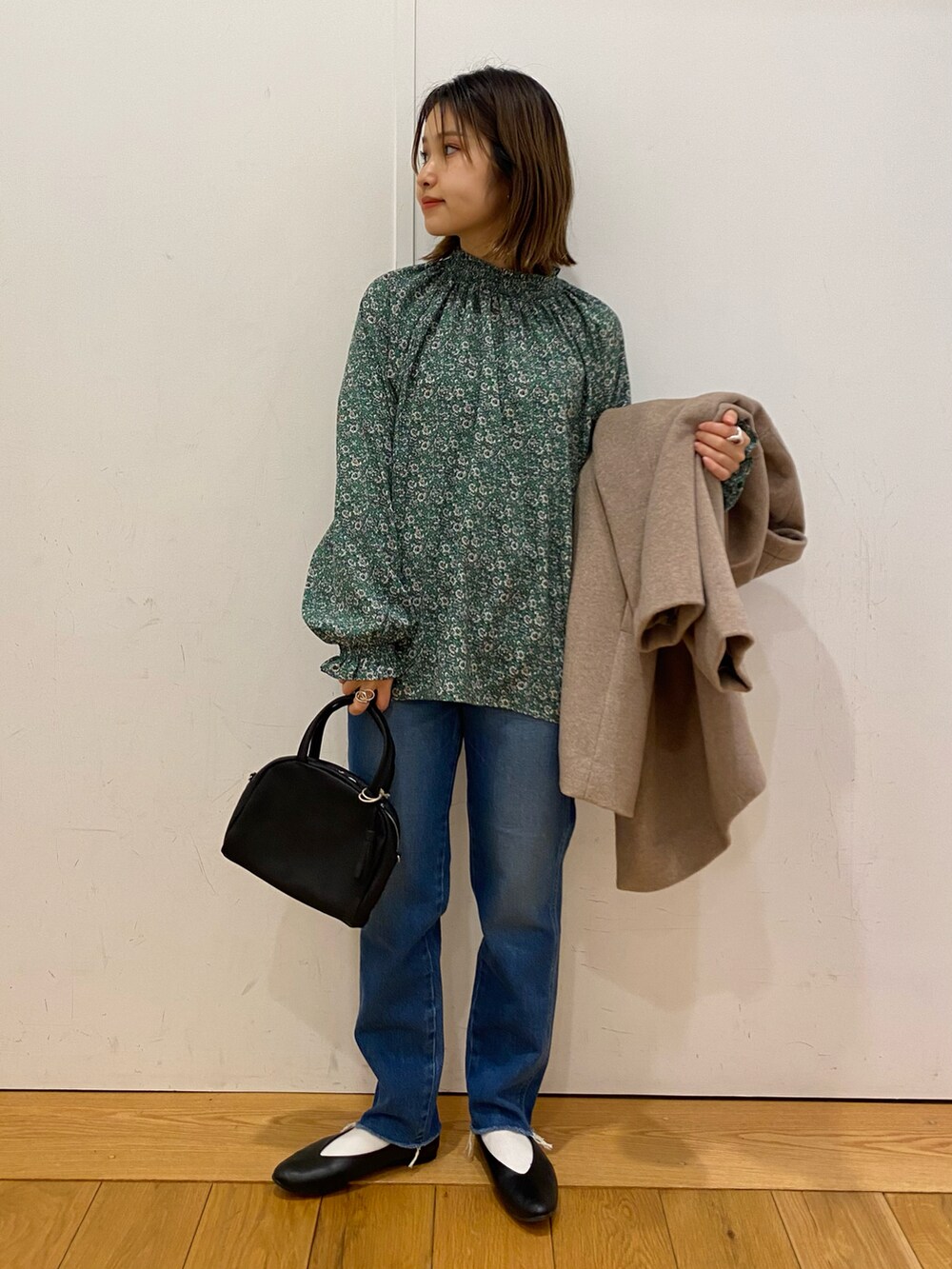 ブルー系のデニムパンツ、ブラック系のパンプス、グリーン系のシャツ/ブラウスを着用したレディースの冬コーディネートの3枚目の写真