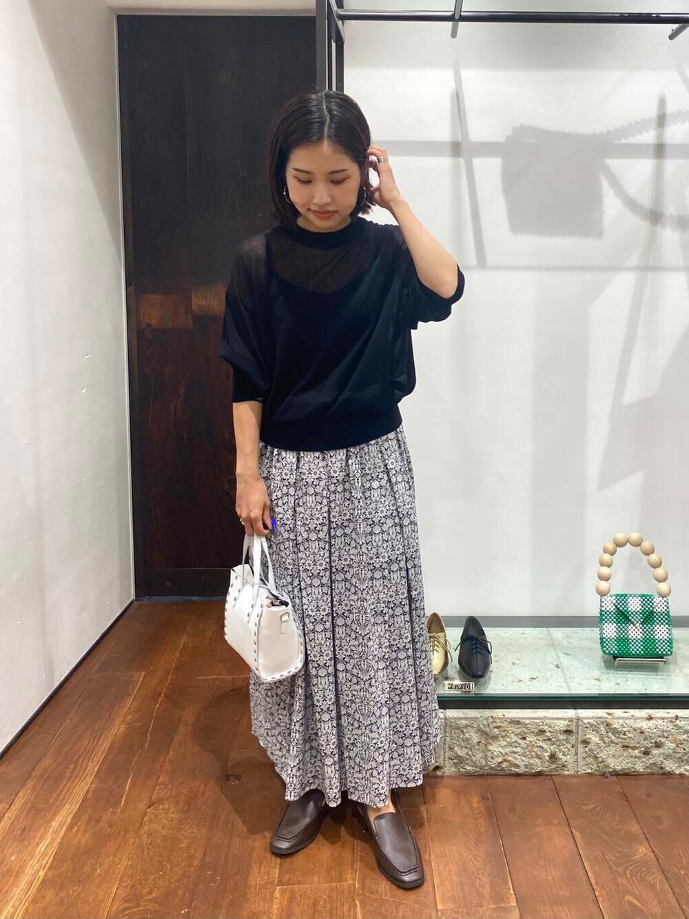 ブラウン系のサンダル、ブルー系のニット/セーター、ホワイト系のショルダーバッグを着用したレディースの夏コーディネートの3枚目の写真