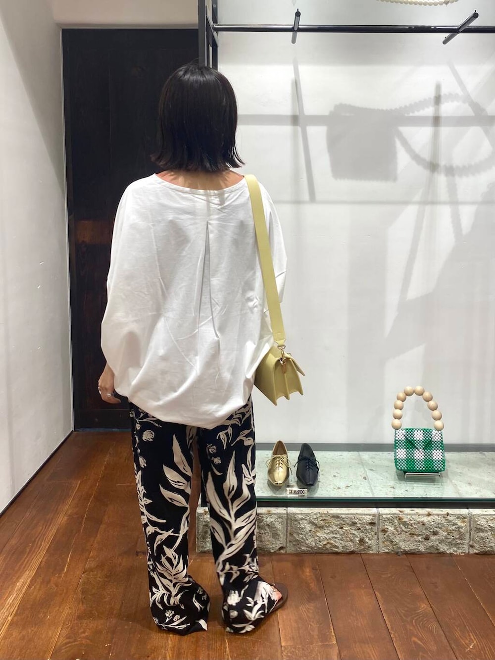 ブラック系のその他パンツ、ブラウン系のサンダル、ホワイト系のTシャツ/カットソーを着用したレディースの夏コーディネートの3枚目の写真