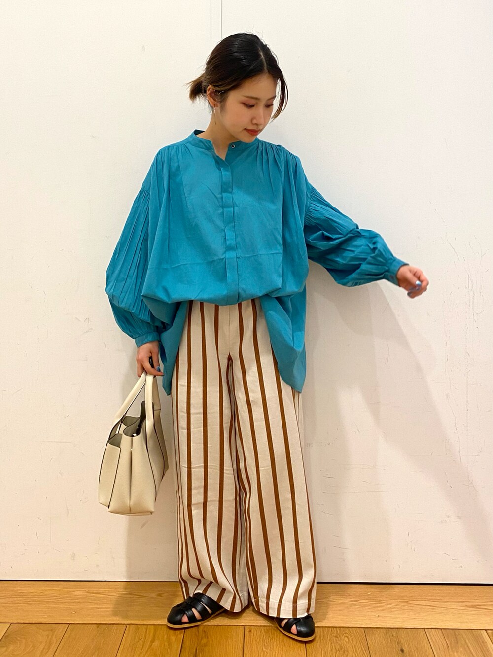 ブラック系のサンダル、ホワイト系のその他パンツ、ブルー系のシャツ/ブラウスを着用したレディースの春コーディネートの2枚目の写真