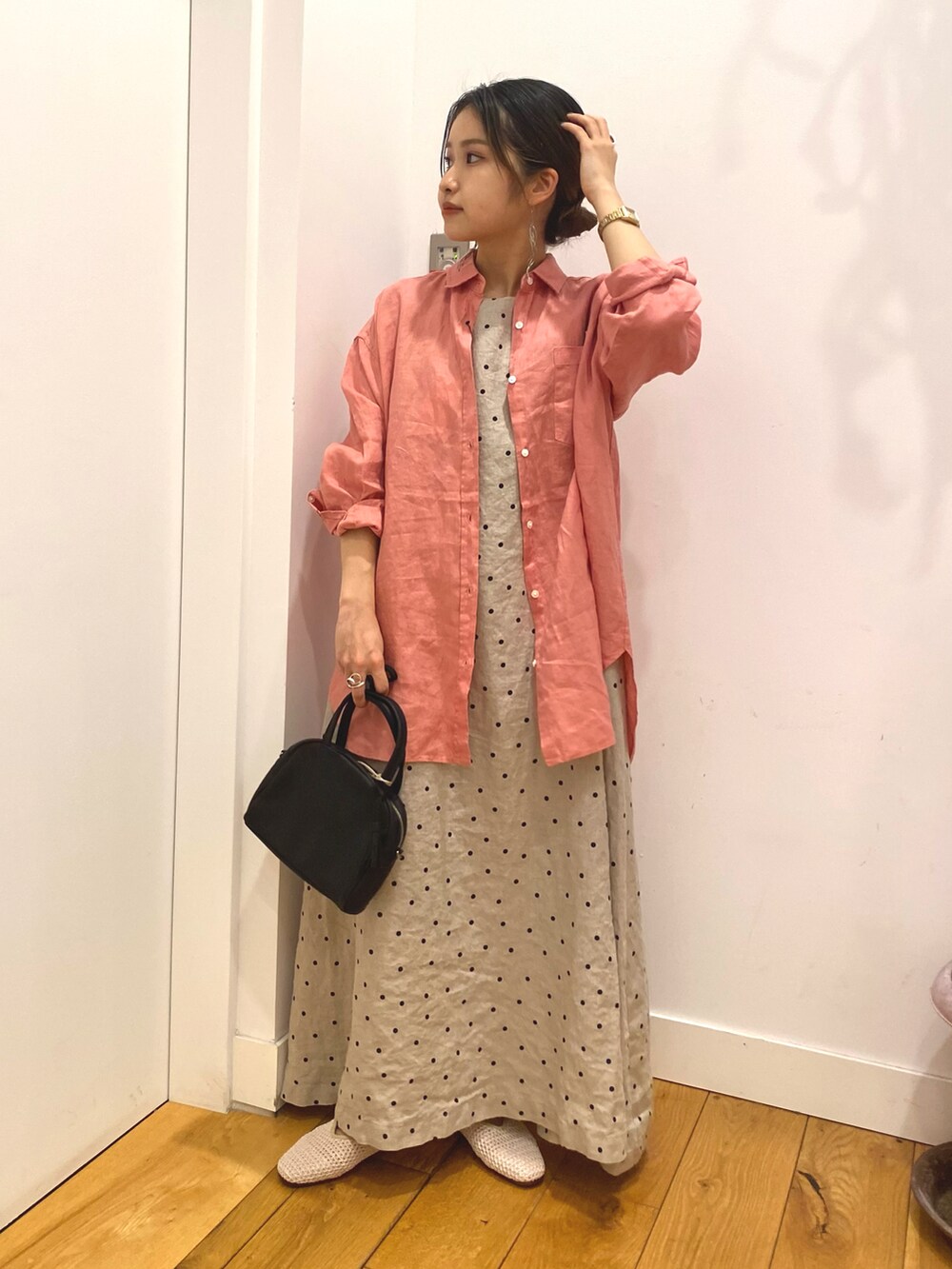 ピンク系のシャツ/ブラウス、ベージュ系のワンピース、ホワイト系のサンダルを着用したレディースの春コーディネートの2枚目の写真