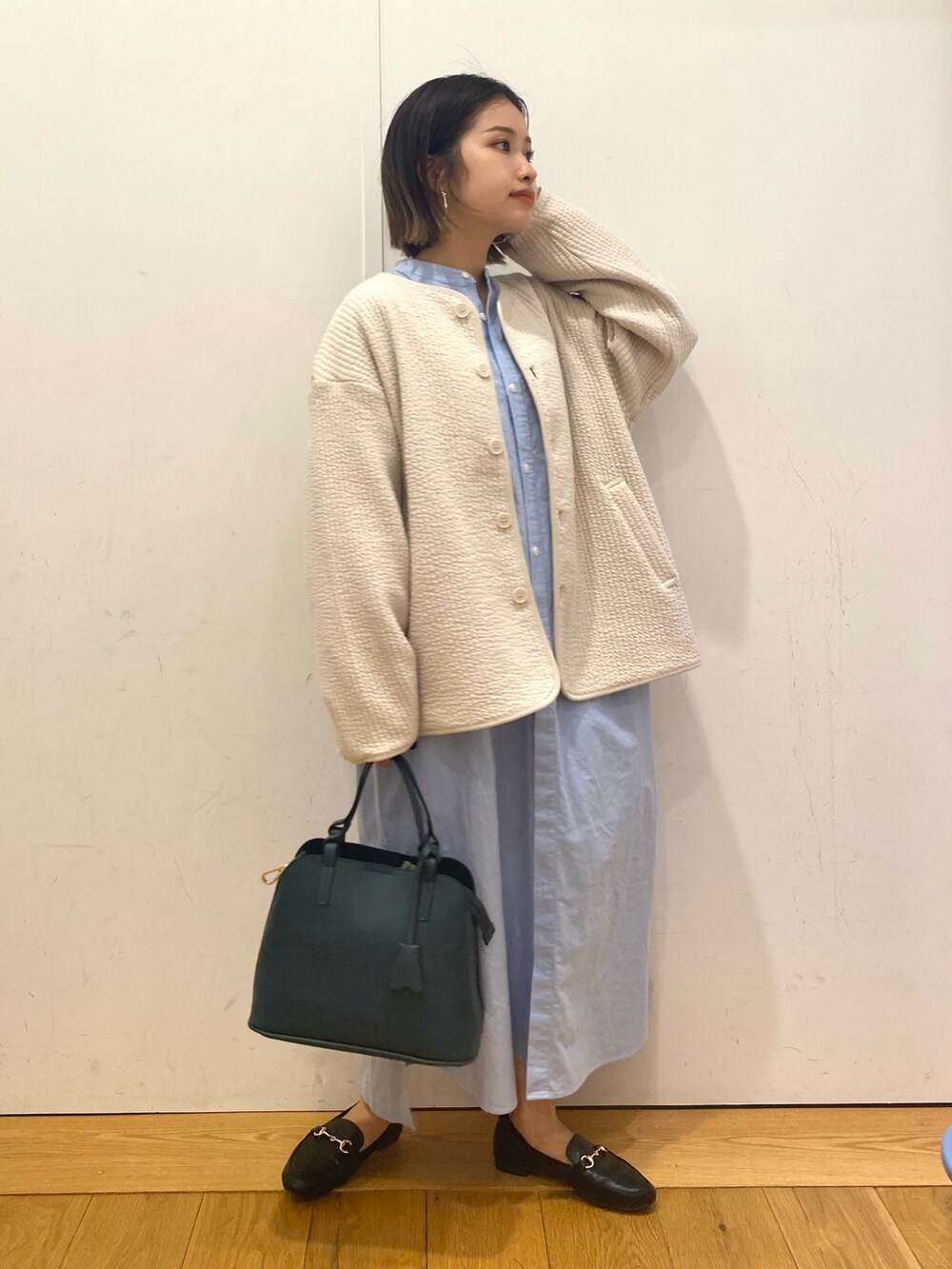 ブラック系のローファー、グリーン系のハンドバッグを着用したレディースの秋コーディネートの2枚目の写真