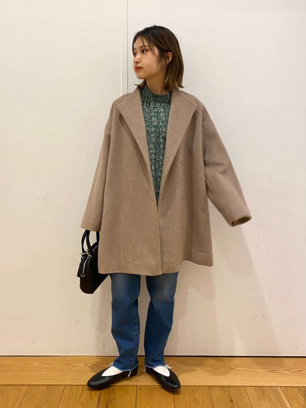 ブルー系のデニムパンツ、ブラック系のパンプス、グリーン系のシャツ/ブラウスを着用したレディースの冬コーディネートの2枚目の写真