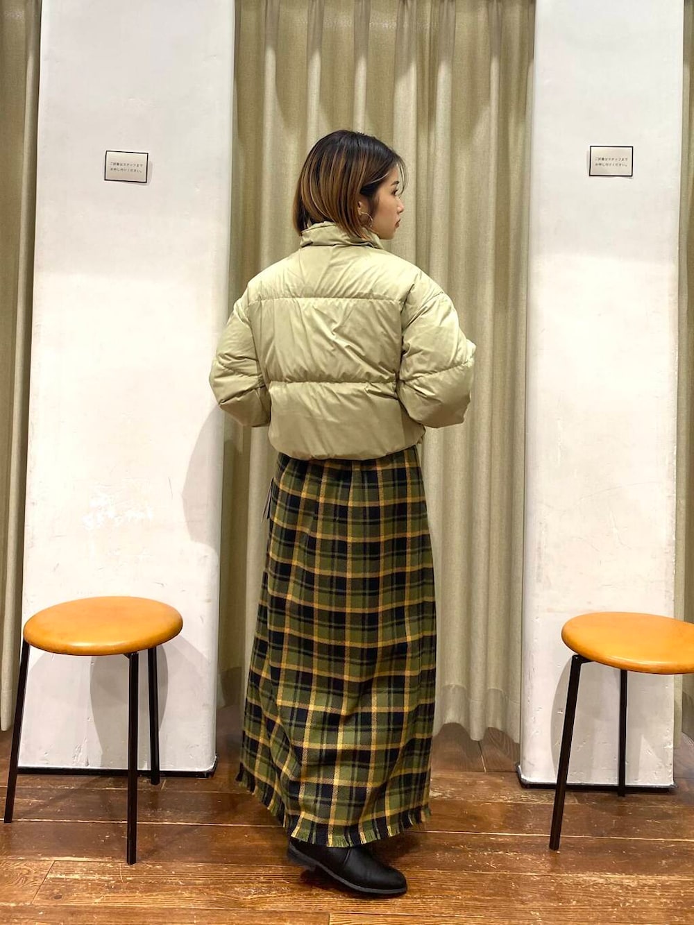 ブラック系のブーツ、グリーン系のスカート、ベージュ系のダウンジャケット/コートを着用したレディースの冬コーディネートの4枚目の写真