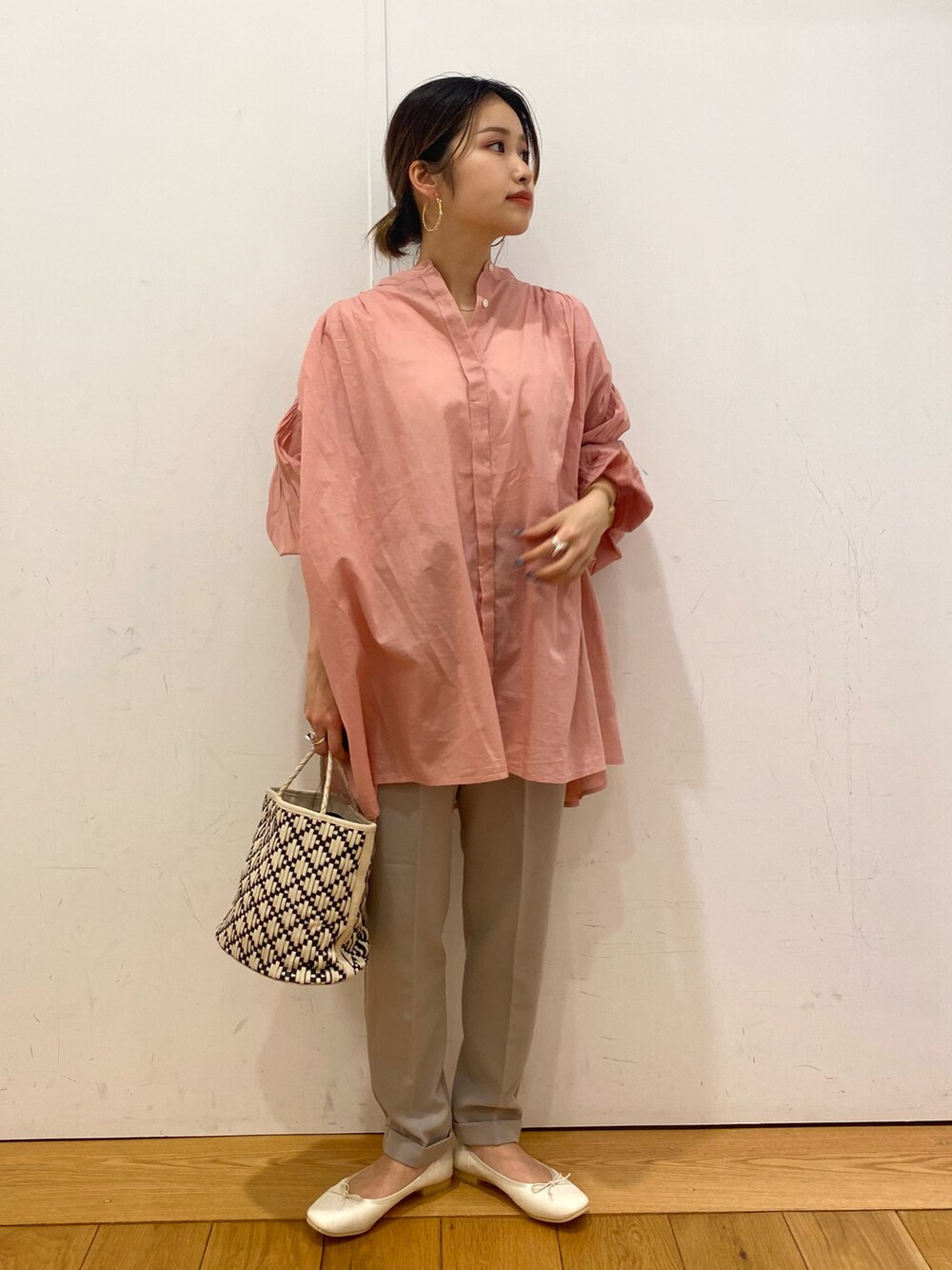 ホワイト系のハンドバッグ、ピンク系のシャツ/ブラウス、ベージュ系のその他パンツを着用したレディースの春コーディネートの2枚目の写真