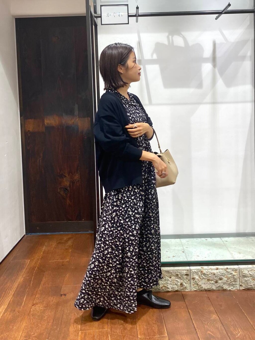 ブラック系のワンピース、ベージュ系のショルダーバッグ、ブラック系のカーディガン/ボレロを着用したレディースの夏コーディネートの2枚目の写真