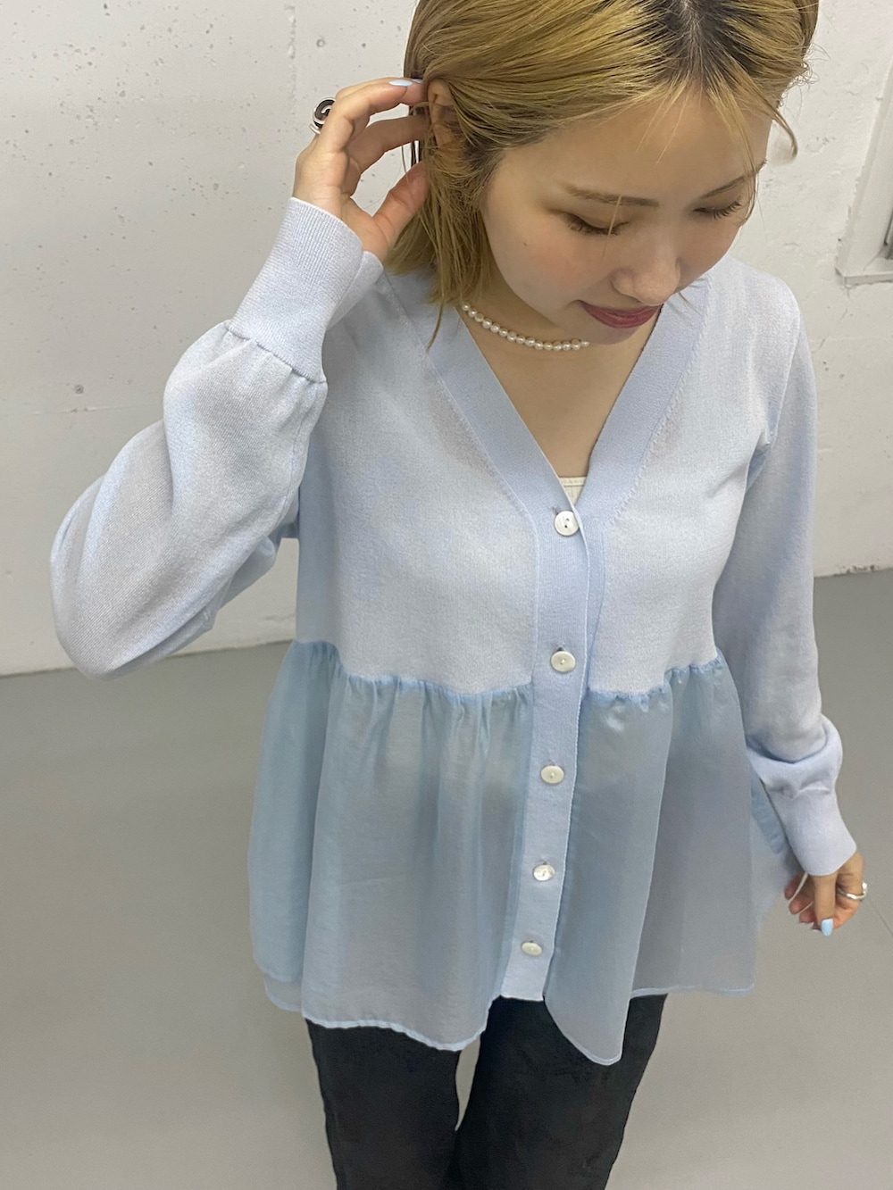 ブルー系のニット/セーターを着用したレディースの春コーディネートの2枚目の写真