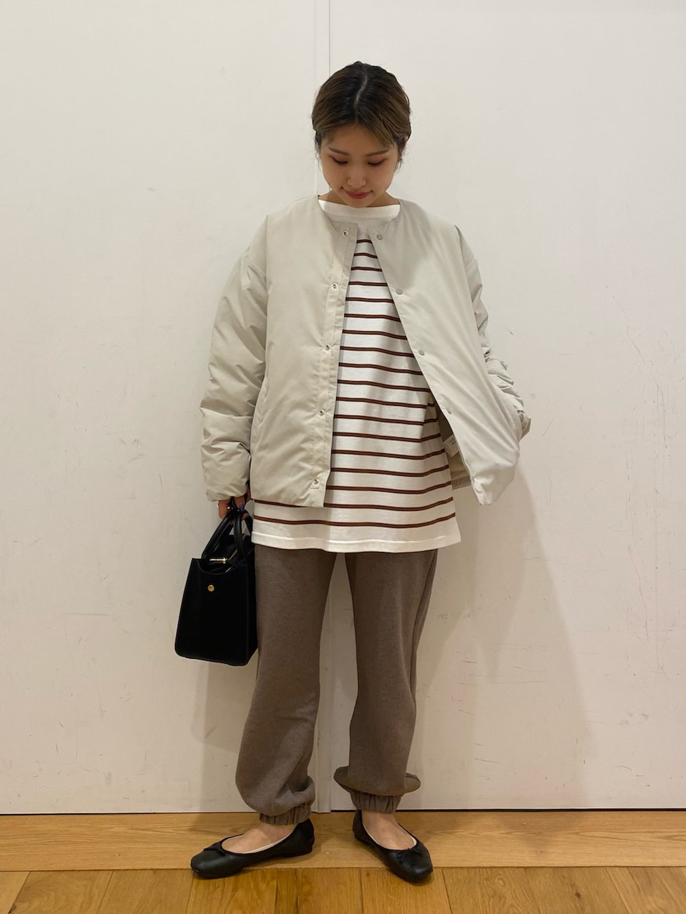 ブラウン系のスウェットパンツ、ブラウン系のTシャツ/カットソー、ブラック系のショルダーバッグを着用したレディースの秋コーディネートの2枚目の写真