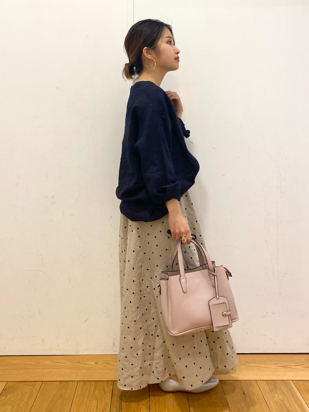 ピンク系のトートバッグ、ブルー系のシャツ/ブラウス、シルバー系のパンプスを着用したレディースの春コーディネートの2枚目の写真