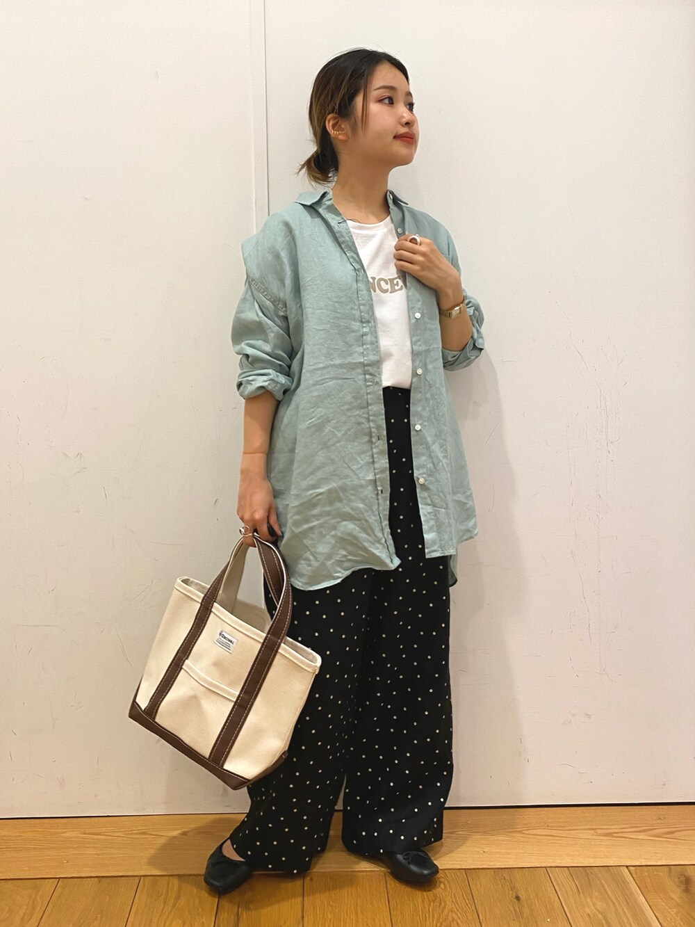 グレー系のTシャツ/カットソー、ブラウン系のトートバッグ、ブラック系のその他パンツを着用したレディースの春コーディネートの2枚目の写真