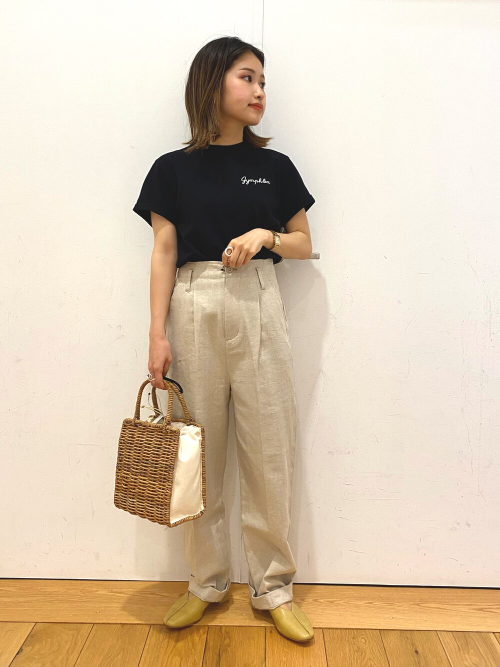 ホワイト系のハンドバッグ、ブラック系のTシャツ/カットソー、ベージュ系のその他パンツを着用したレディースの夏コーディネートの2枚目の写真