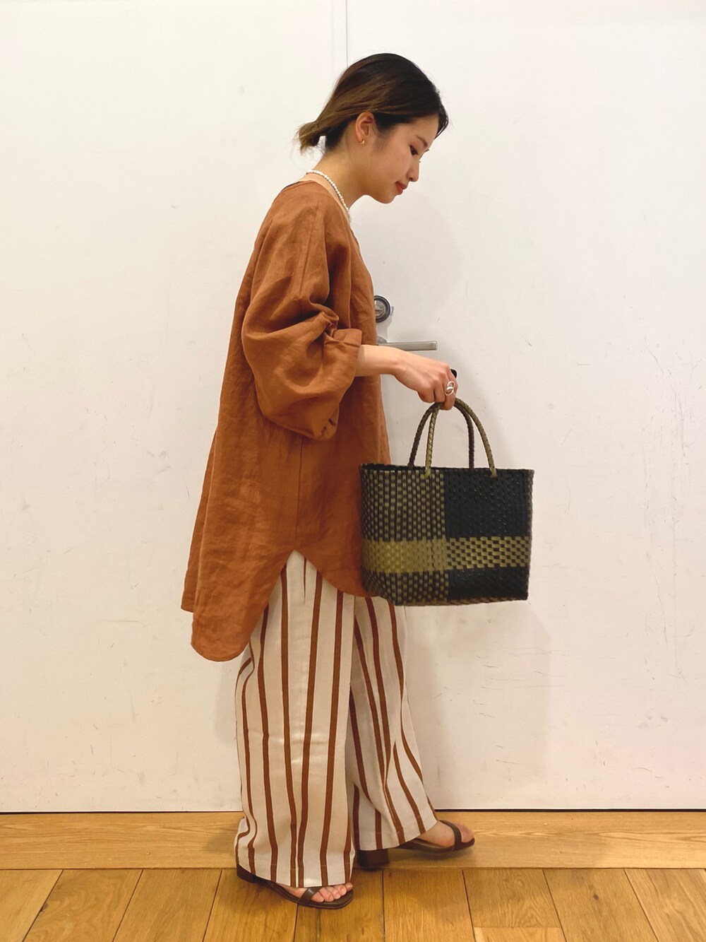 ブラック系のトートバッグ、ブラウン系のシャツ/ブラウス、ホワイト系のその他パンツを着用したレディースの春コーディネートの3枚目の写真