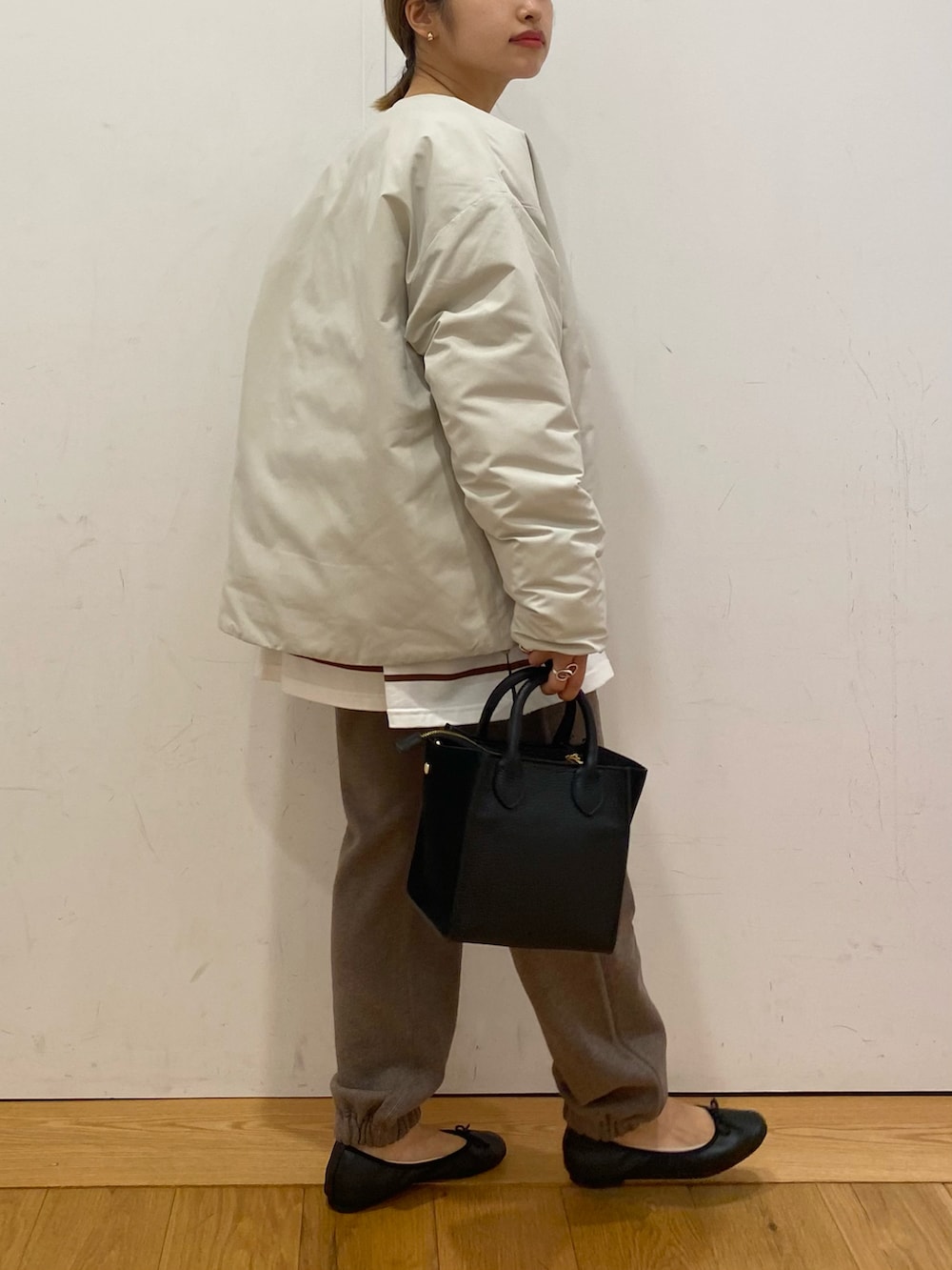 ブラウン系のスウェットパンツ、ブラウン系のTシャツ/カットソー、ブラック系のショルダーバッグを着用したレディースの秋コーディネートの4枚目の写真