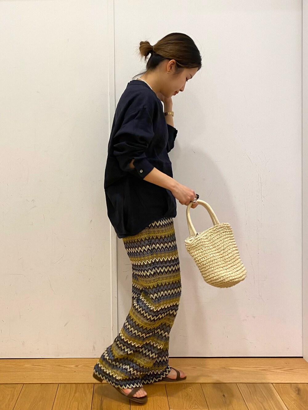 ベージュ系のショルダーバッグ、ブラウン系のサンダル、ブルー系のシャツ/ブラウスを着用したレディースの春コーディネートの2枚目の写真