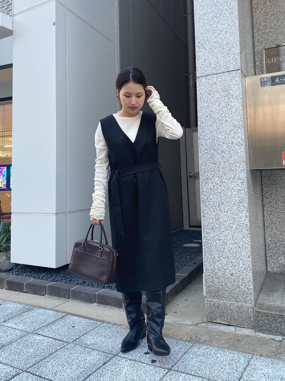 ブラック系のワンピースを着用したレディースの秋コーディネートの2枚目の写真