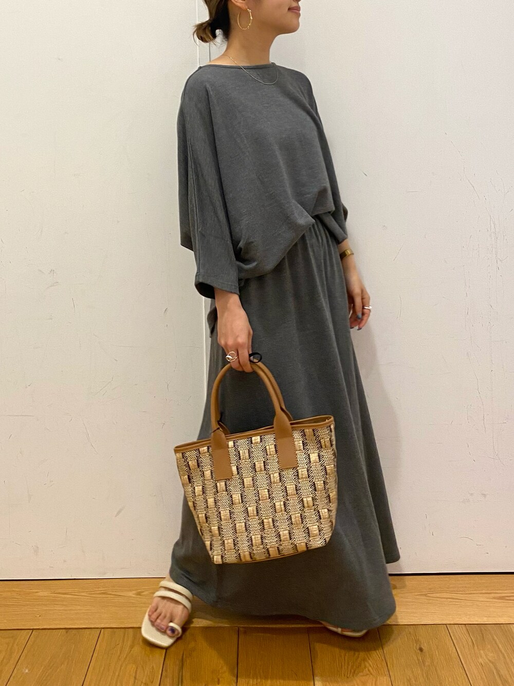 ベージュ系のバッグ、グレー系のTシャツ/カットソー、グレー系のスカートを着用したレディースの夏コーディネートの2枚目の写真