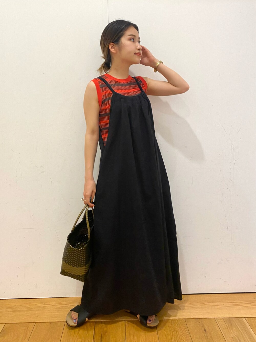 ブラック系のトートバッグ、ブラック系のワンピース、オレンジ系のニット/セーターを着用したレディースの夏コーディネートの3枚目の写真