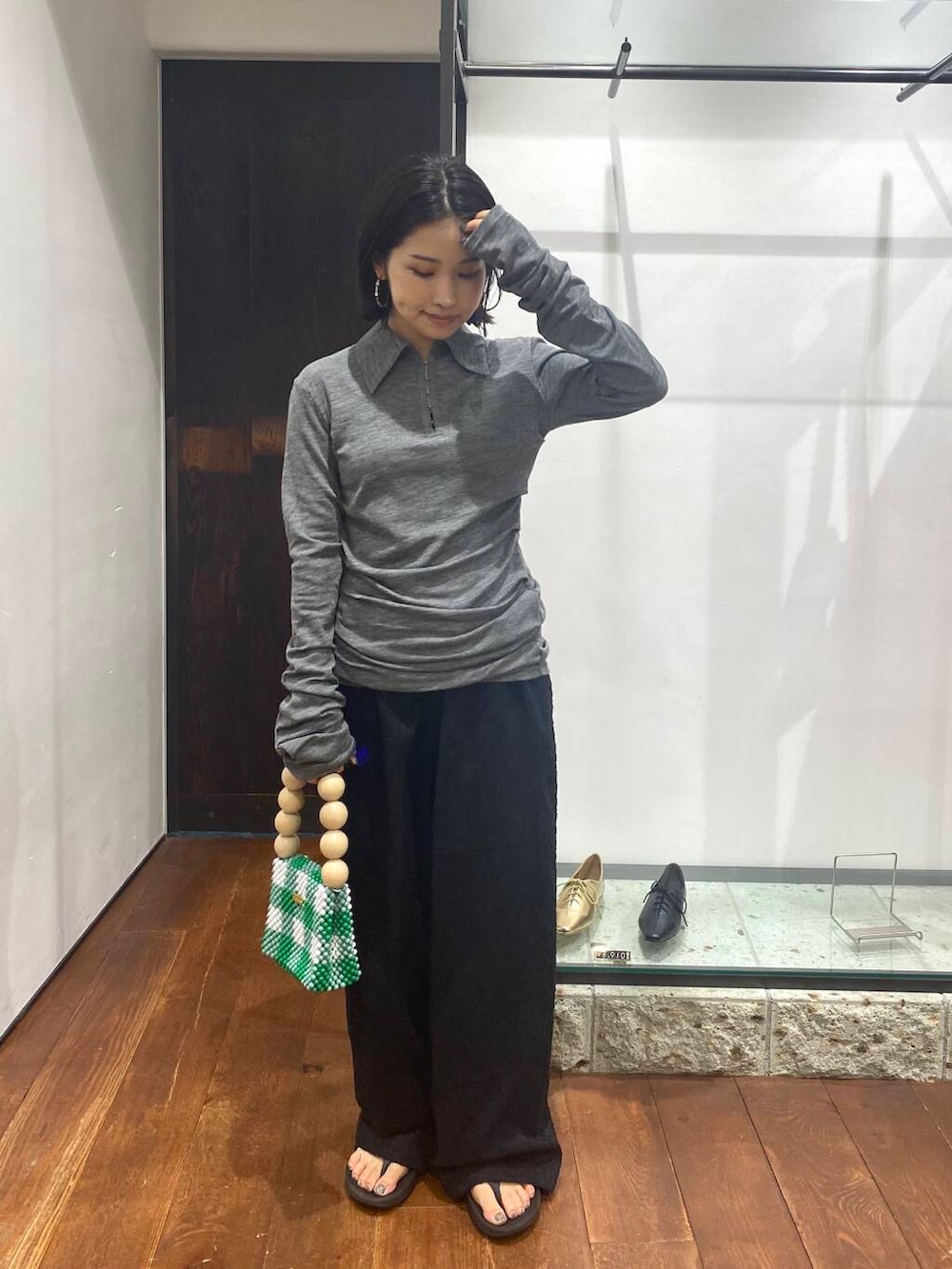 ブラック系のその他パンツ、その他のハンドバッグ、グレー系のニット/セーターを着用したレディースの夏コーディネートの2枚目の写真