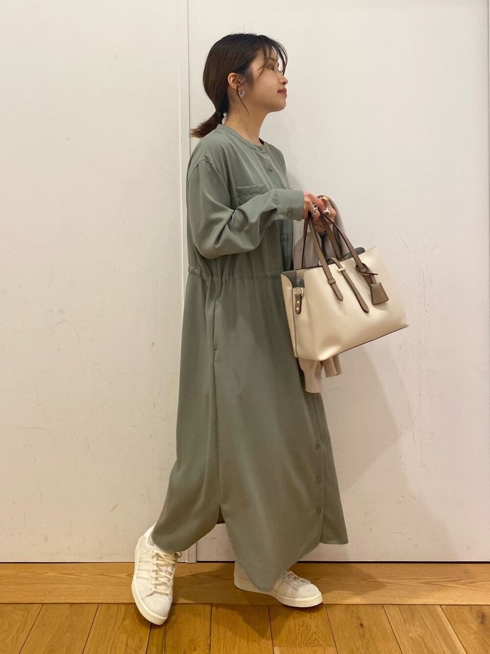 ホワイト系のトートバッグ、グリーン系のワンピース、ベージュ系のカーディガン/ボレロを着用したレディースの春コーディネートの3枚目の写真