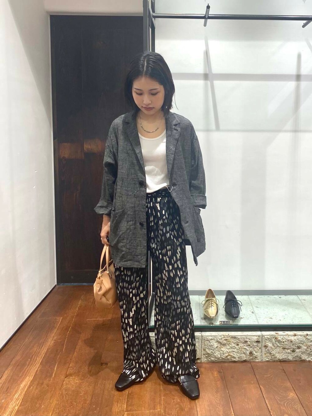 ブラック系のローファー、ホワイト系のタンクトップ、ベージュ系のショルダーバッグを着用したレディースの夏コーディネートの4枚目の写真