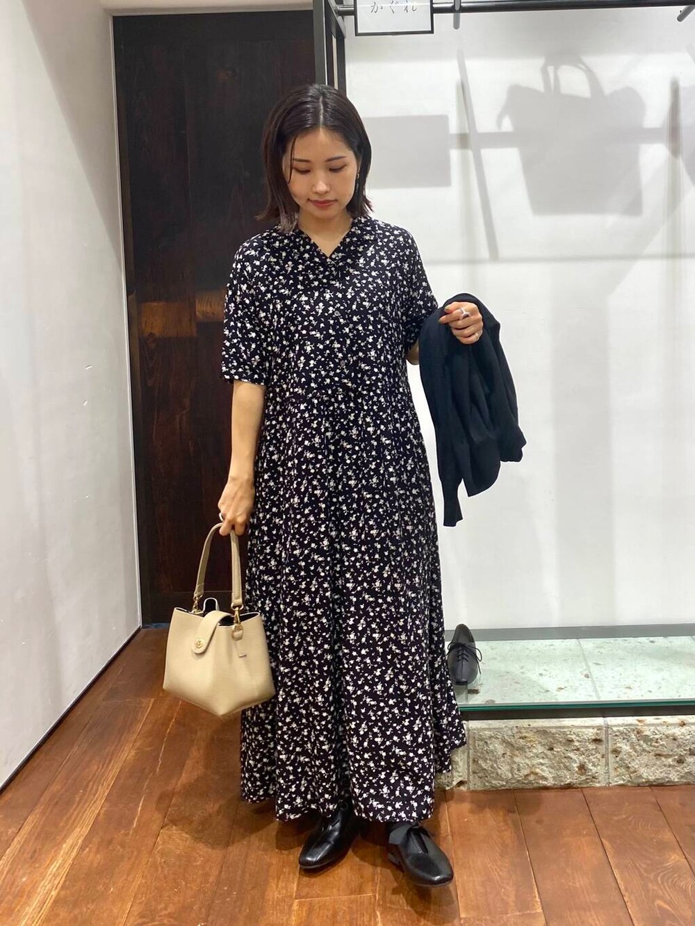 ブラック系のワンピース、ベージュ系のショルダーバッグ、ブラック系のカーディガン/ボレロを着用したレディースの夏コーディネートの5枚目の写真