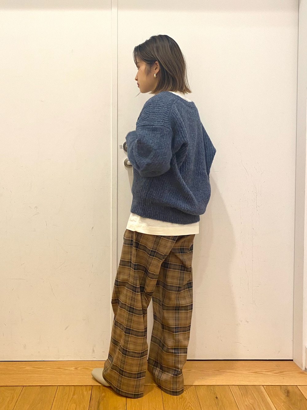 ブルー系のニット/セーター、ホワイト系のTシャツ/カットソー、ベージュ系のその他パンツを着用したレディースの冬コーディネートの2枚目の写真