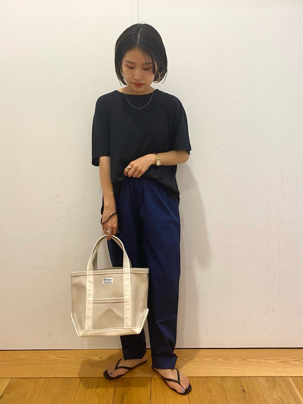 ブルー系のその他パンツ、ホワイト系のトートバッグ、ブラック系のサンダルを着用したレディースの秋コーディネートの2枚目の写真