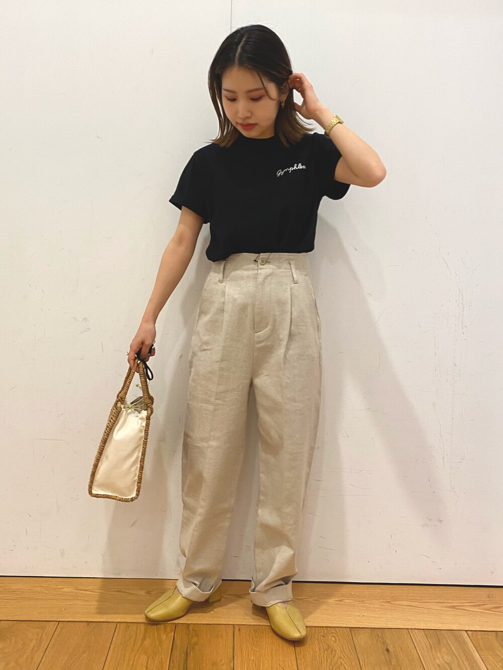 ホワイト系のハンドバッグ、ブラック系のTシャツ/カットソー、ベージュ系のその他パンツを着用したレディースの夏コーディネートの4枚目の写真