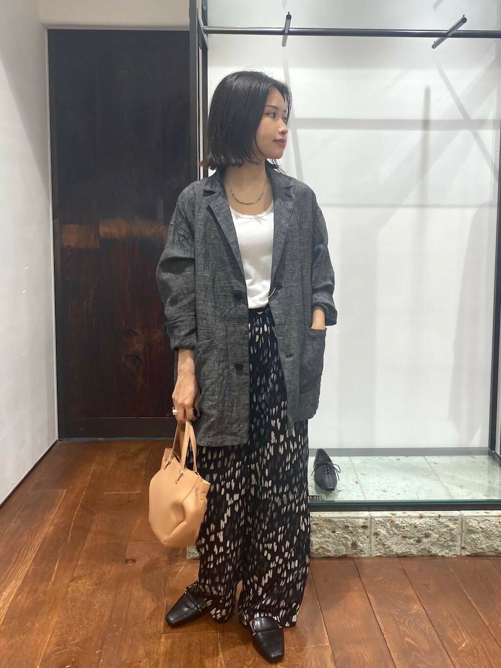 ブラック系のローファー、ホワイト系のタンクトップ、ベージュ系のショルダーバッグを着用したレディースの夏コーディネートの2枚目の写真