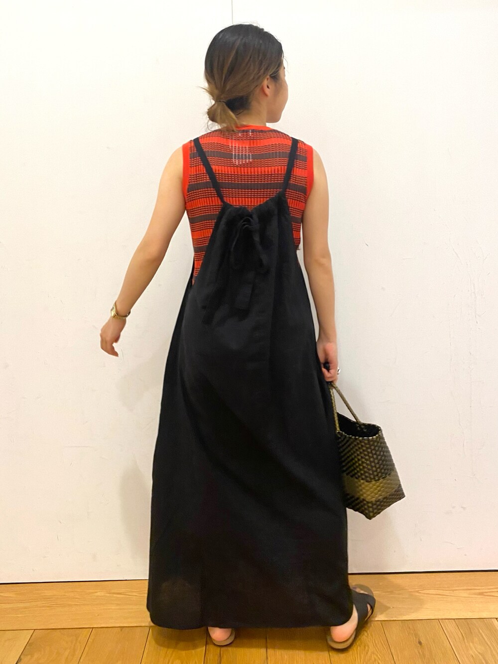 ブラック系のトートバッグ、ブラック系のワンピース、オレンジ系のニット/セーターを着用したレディースの夏コーディネートの4枚目の写真